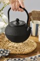 Czajnik żeliwny z emaliowanym wnętrzem i sitkiem do herbaty, który doskonale utrzymuje ciepło i podkreśla charakter stołu. Produkt dostępny w Ulica Ceramiczna & Home Design.