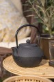 Czajnik żeliwny z emaliowanym wnętrzem i sitkiem do herbaty, który doskonale utrzymuje ciepło i podkreśla charakter stołu. Produkt dostępny w Ulica Ceramiczna & Home Design.