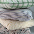 Poszewka Miljögården w zieloną kratkę o strukturze lnu to ponadczasowy dodatek do wnętrz dostępny w Ulica Ceramiczna & Home Design.