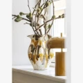 Lampa stołowa Madam Stoltz w kolorze ciemnej musztardy z mosiężnymi detalami to stylowy element oświetlenia, dostępny w Ulica Ceramiczna & Home Design.