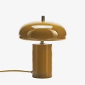 Lampa stołowa Madam Stoltz w kolorze ciemnej musztardy z mosiężnymi detalami to stylowy element oświetlenia, dostępny w Ulica Ceramiczna & Home Design.