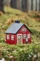 Czerwony domek ceramiczny Ib Laursen na tealight z prezentem na saniach – świąteczna dekoracja do ceramicznej wioski.