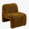Designerski fotel boucle Madam Stoltz w kolorze musztardowym z miękką tapicerką i rzeźbiarską bryłą.